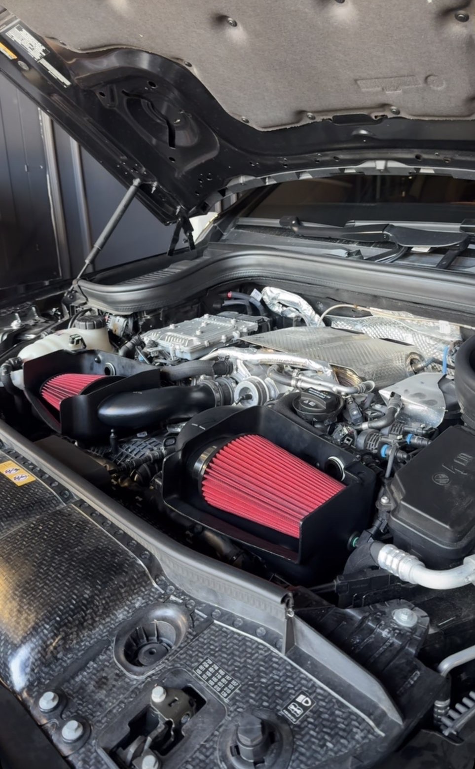 Detailed engine bay with twin cold air intakes after an engine bay cleaning